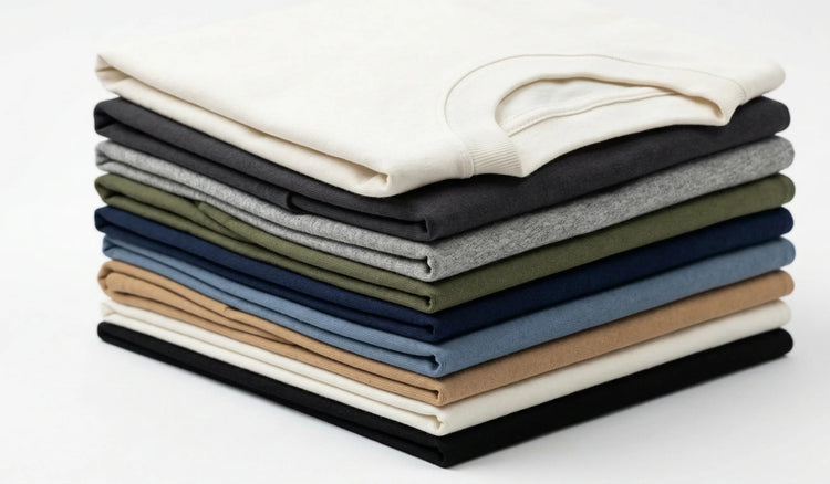 Stack of folded shirts in various colors on a white background